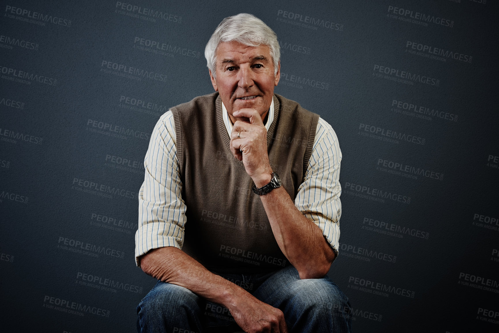 Buy stock photo Studio portrait of a handsome mature man looking thoughtful while sitting on a stool against a dark background