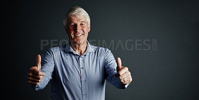 Buy stock photo Studio portrait of a handsome mature man giving you an approving thumbs up against a dark background