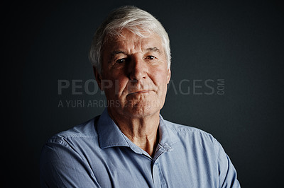 Buy stock photo Studio portrait of a handsome mature man posing against a dark background