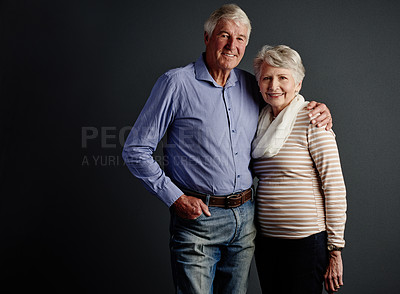 Buy stock photo Studio portrait of an affectionate senior couple posing against a grey background