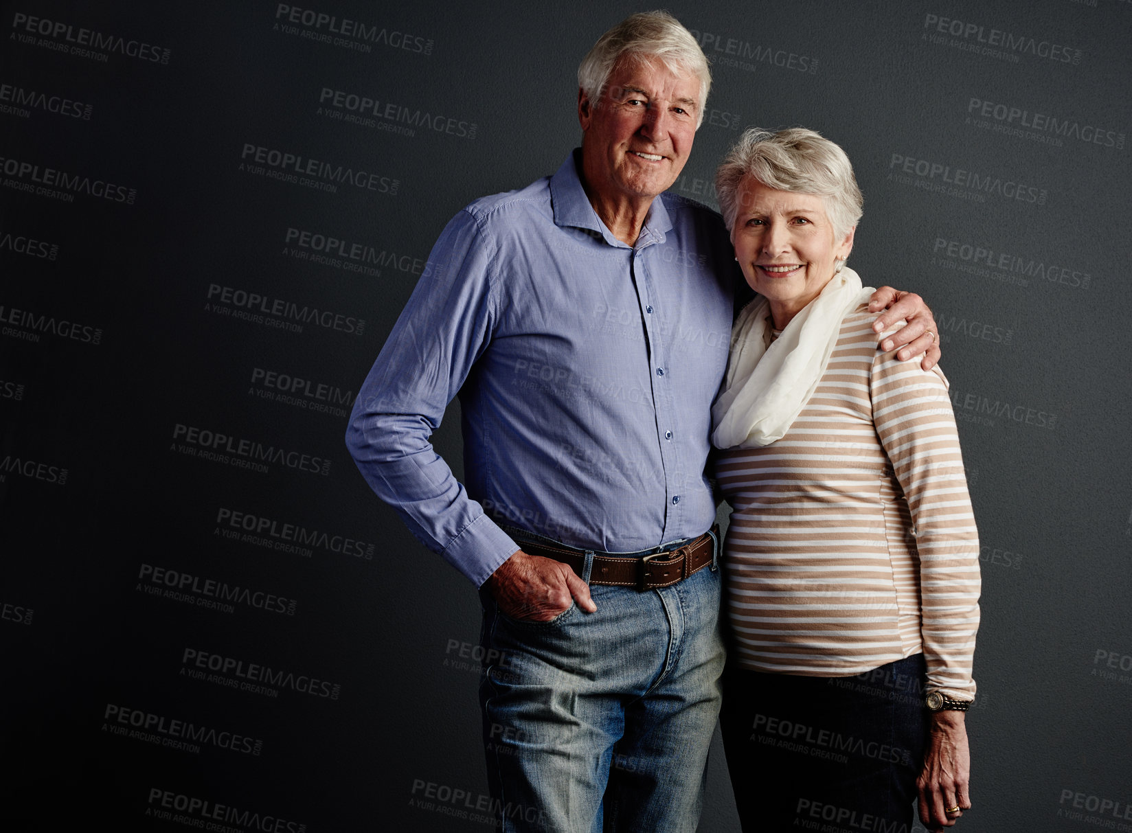 Buy stock photo Studio portrait of an affectionate senior couple posing against a grey background