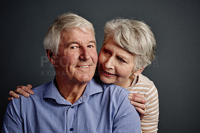 Buy stock photo Studio portrait of an affectionate senior couple posing against a grey background