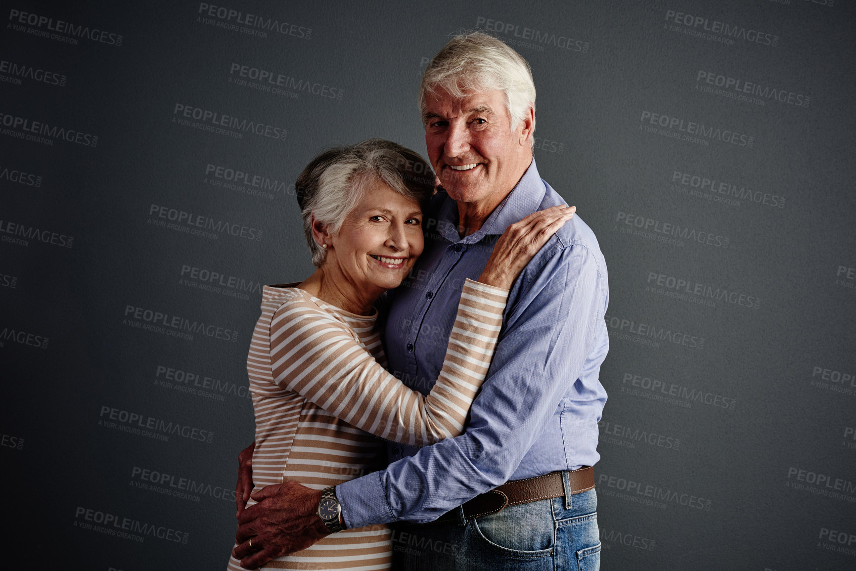 Buy stock photo Portrait, love and hug with elderly couple in studio, loyalty and care on valentines day. Smile, senior man and woman embrace together for connection, retirement and support on gray background space