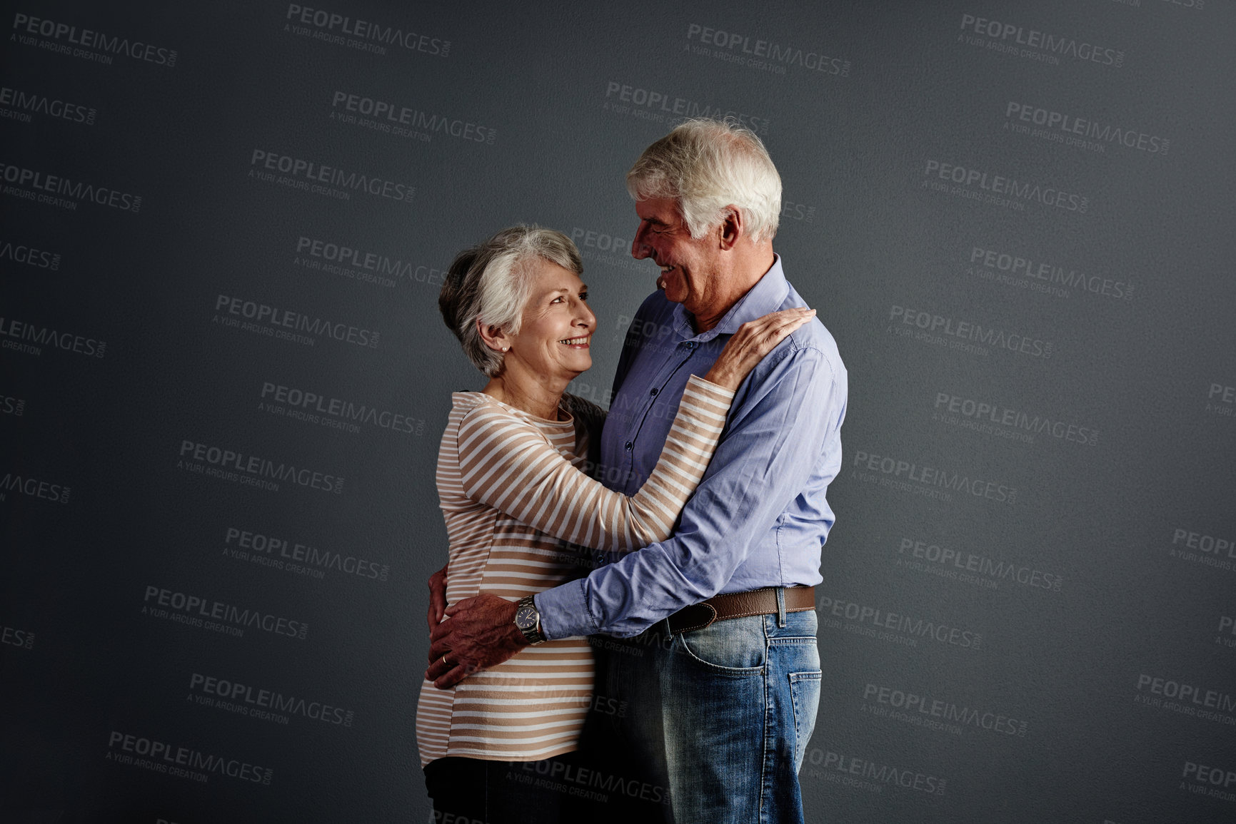 Buy stock photo Studio shot of an affectionate senior couple posing against a grey background