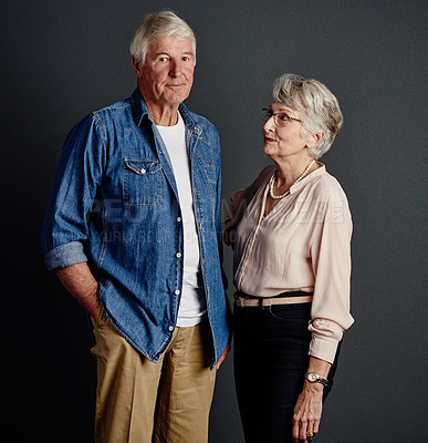 Buy stock photo Studio portrait of an affectionate senior couple posing against a grey background