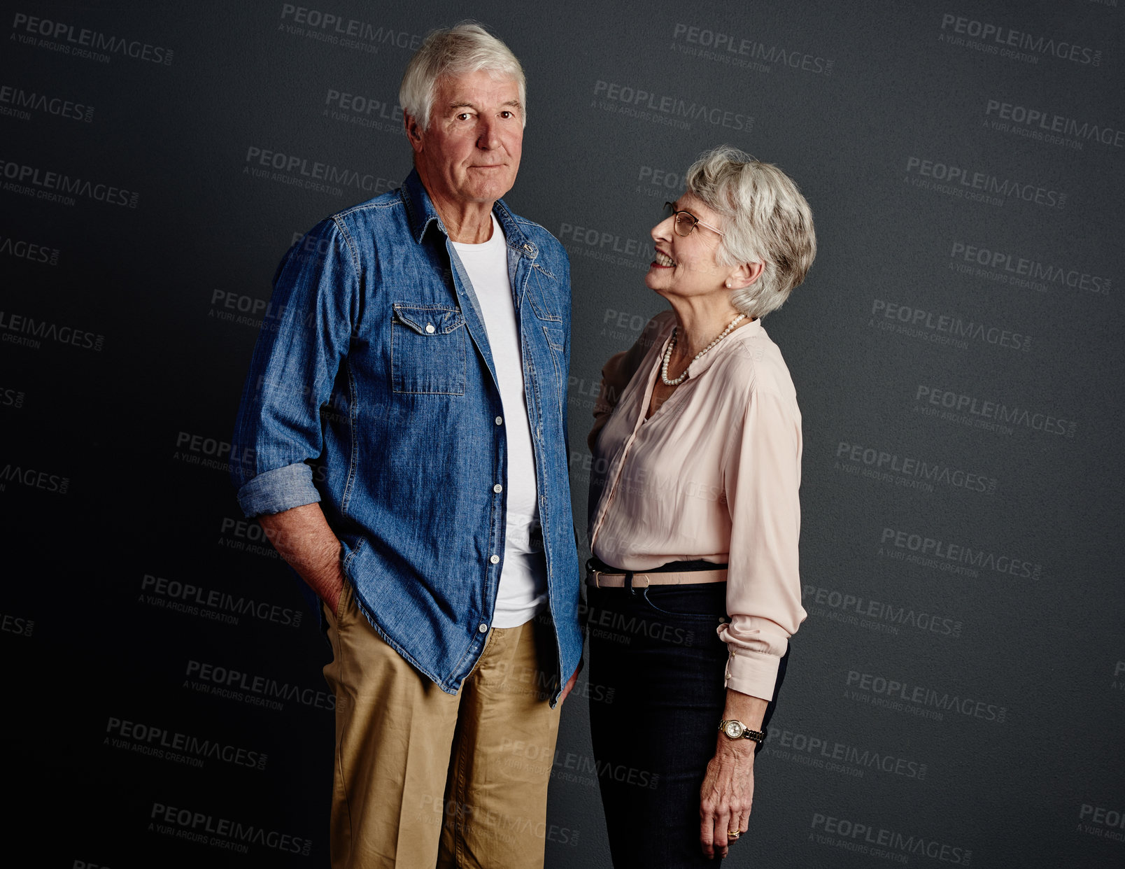 Buy stock photo Studio portrait of an affectionate senior couple posing against a grey background