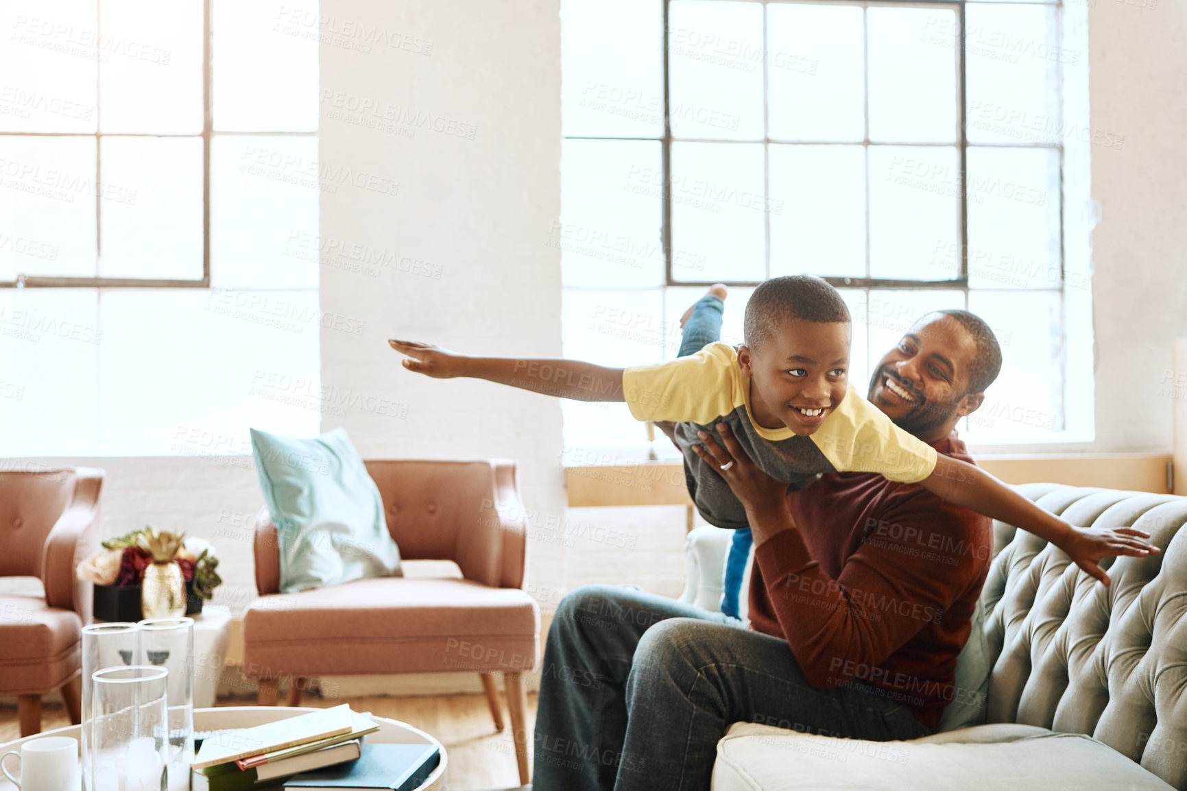 Buy stock photo Airplane, game and father with son on a sofa, playing and bonding in their home together. Love, family and parent enjoy relationship with smiling boy, fly and fun in the living room on the weekend