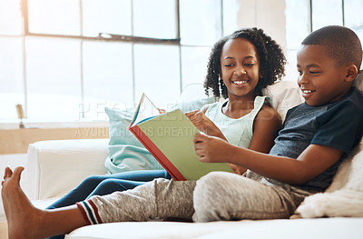 Buy stock photo Shot of a little brother and sister reading a book indoors