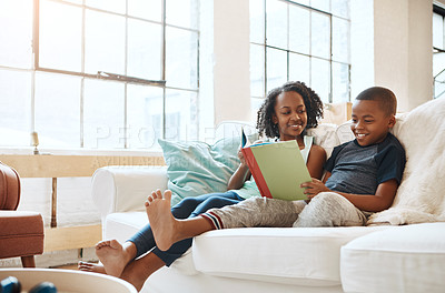 Buy stock photo Shot of a little brother and sister reading a book indoors