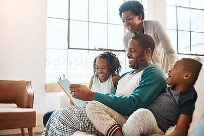 Buy stock photo Shot of a family reading a book indoors