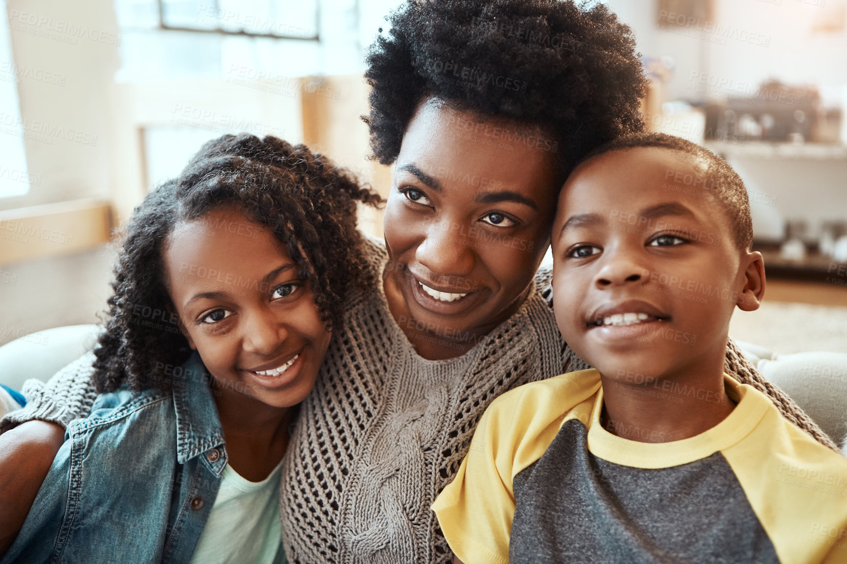 Buy stock photo Shot a mother and her children sitting on the sofa together indoors