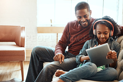 Buy stock photo Shot of a father and daughter using a tablet indoors