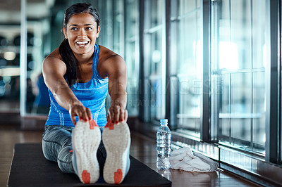 Buy stock photo Shot of an attractive young woman going through her warmup routine in the gym