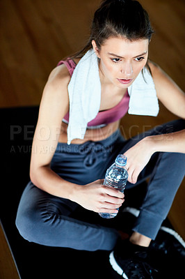 Buy stock photo High angle shot of an attractive young woman taking a break during her workout in the gym