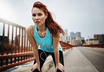 Buy stock photo Portrait of a sporty young woman taking a break while running in the city