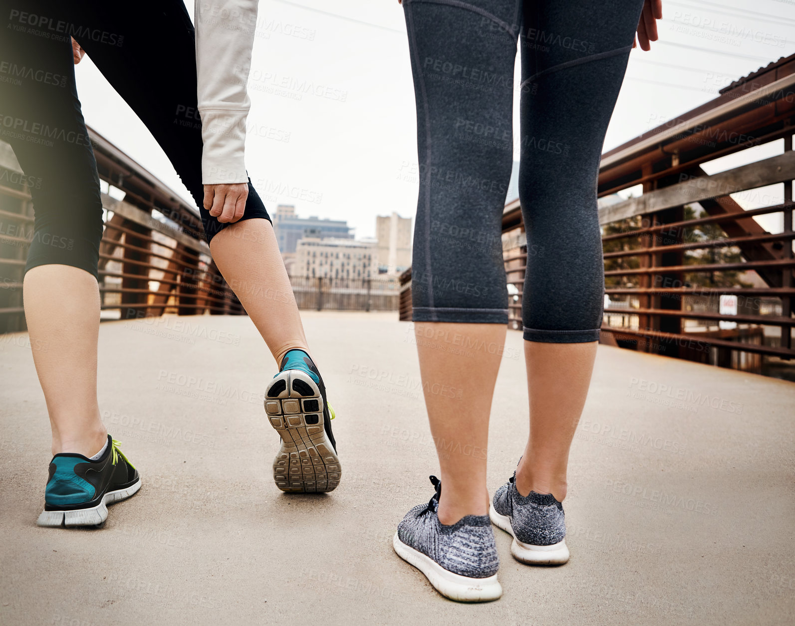 Buy stock photo Rearview shot of two unrecognizable young women running through the city