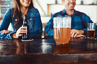 Buy stock photo Shot of an unrecognizable couple enjoying a drink at a bar