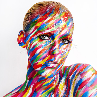 Buy stock photo Studio shot of a young woman posing with brightly colored paint on her face against a white background