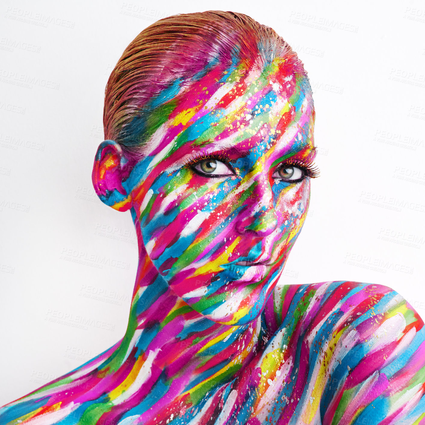 Buy stock photo Studio shot of a young woman posing with brightly colored paint on her face against a white background