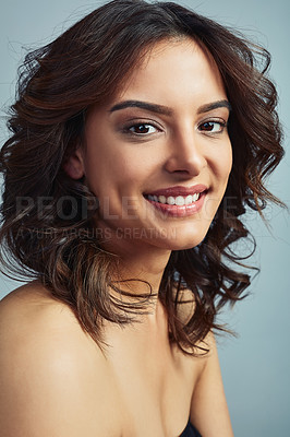 Buy stock photo Studio portrait of a beautiful young woman with flawless skin against a grey background