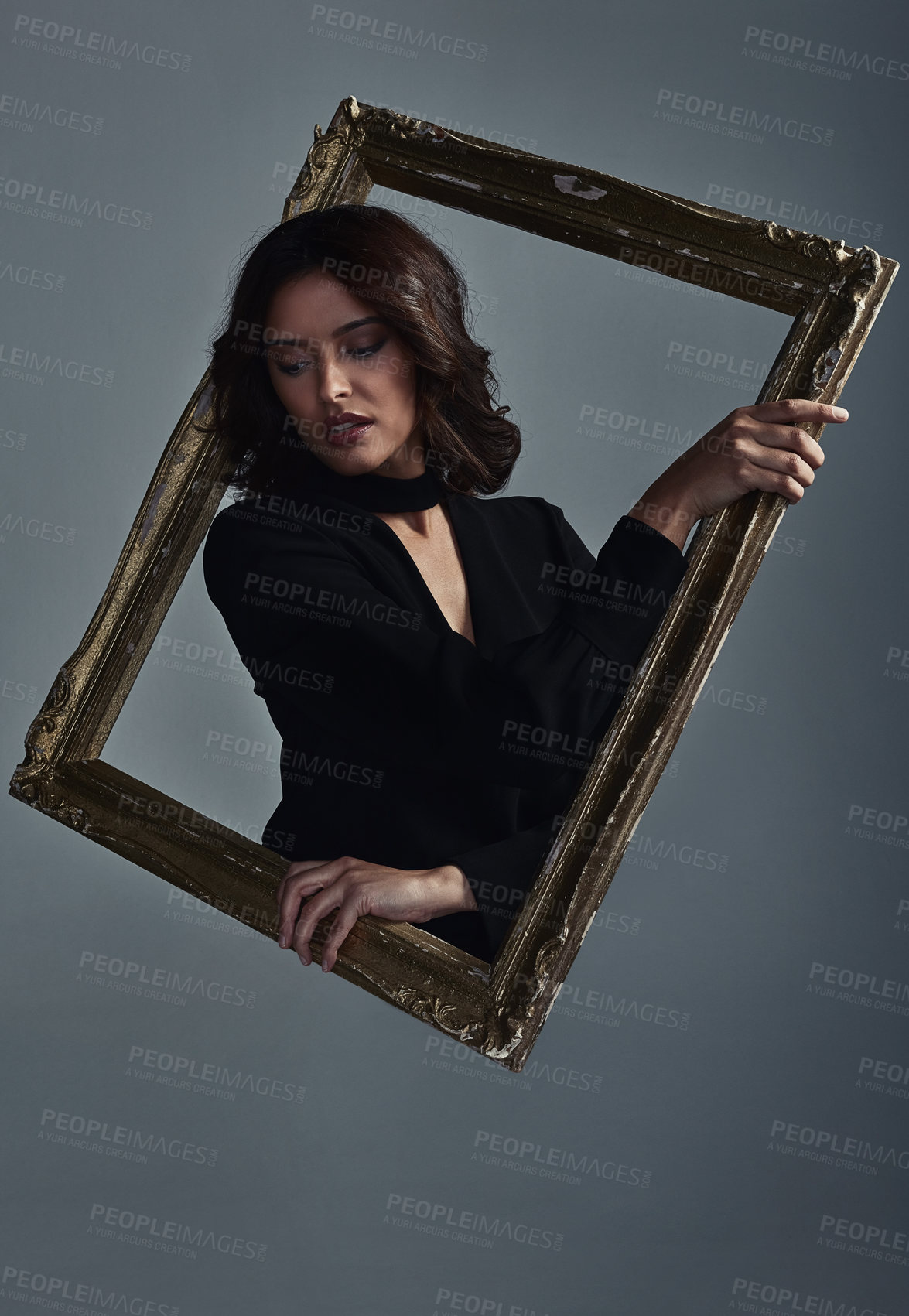 Buy stock photo Studio shot of a beautiful young woman going through a mirror against a grey background