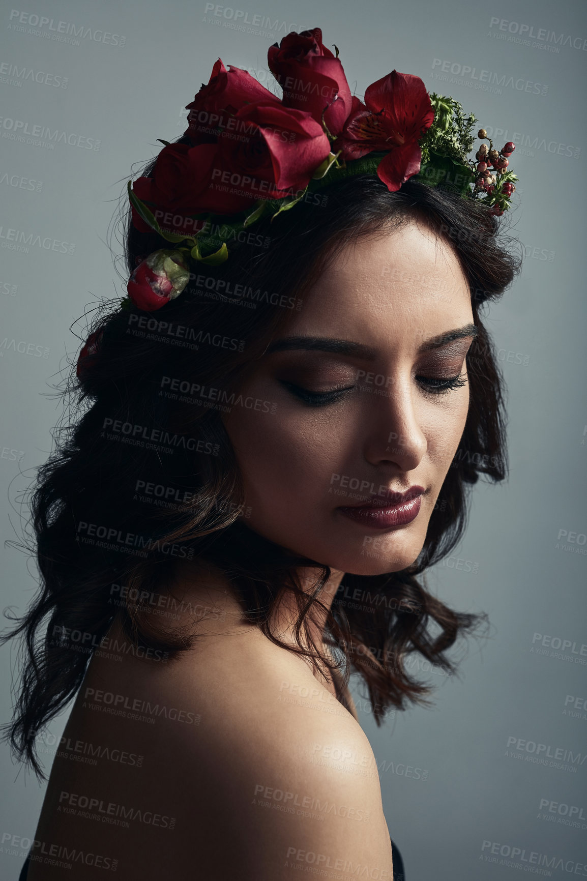 Buy stock photo Studio shot of a beautiful young woman wearing a floral head wreath against a grey background