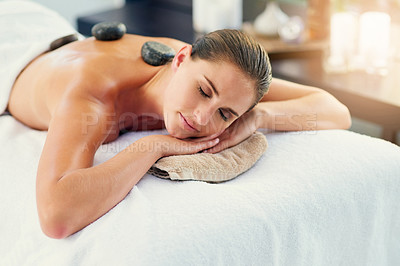 Buy stock photo Face, hot stone and massage with woman in spa to relax as customer for hospitality or wellness. Alternative, holistic and peace with person sleeping in luxury hotel for detox, retreat or treatment