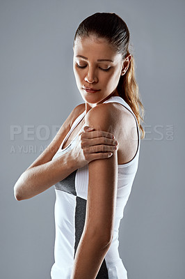 Buy stock photo Woman, fitness and arms with sports injury for shoulder pain, accident or ache on a gray studio background. Female person or athlete with bruise, sore muscle or inflammation from sprain or tension