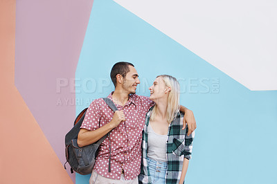 Buy stock photo Shot of a cheerful young couple standing outside holding one another and looking into each other's eyes