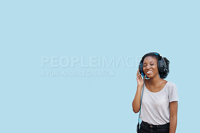 Buy stock photo Music, portrait and black woman with headphones in studio for sound, track or listening to podcast on blue background. Streaming, mockup or gen z African student with radio, playlist or audio ebook