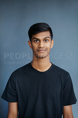 Buy stock photo Studio, portrait and smile of Indian student, confidence and guy with tshirt, fashion and college. University, gen z and male person, school and blue background, pride and face of model and yearbook
