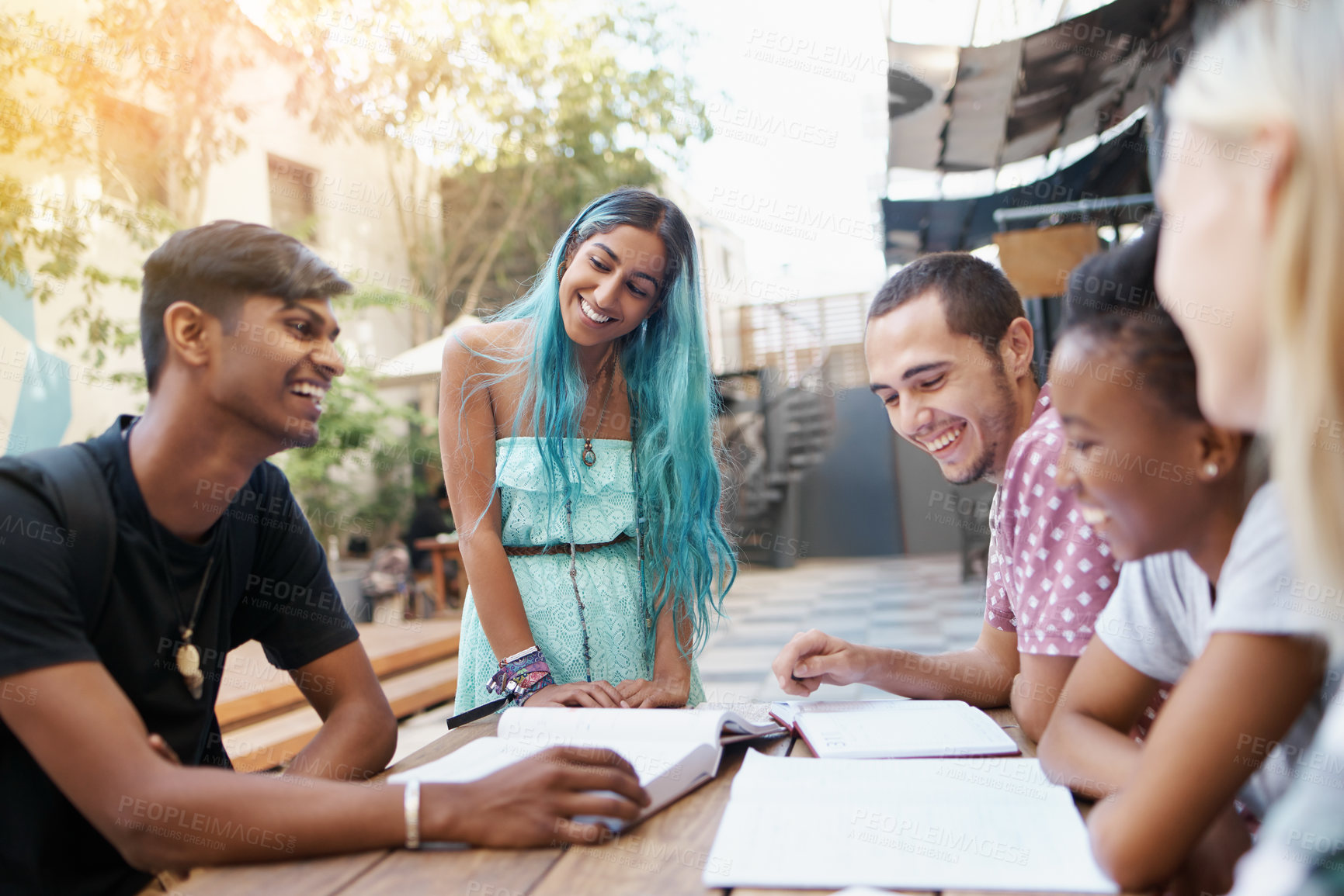 Buy stock photo Students, people and learning outdoor at university with books, funny and study for education on campus. Friends, gen z group and teamwork research with laughing, diversity and college break by table