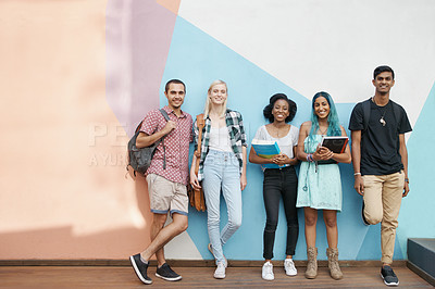 Buy stock photo Shot of a group of cheerful young students standing outside and talking before class while looking at the camera