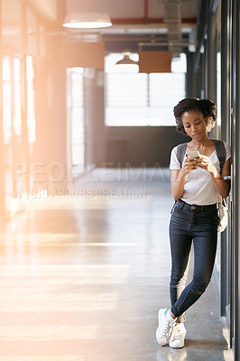 Buy stock photo African, girl and phone at university for typing or communication, technology or online and conversation. Female student, school or standing in hallway with mobile for app, internet or email with 5g