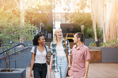 Buy stock photo Shot of a group of happy young friends walking together outside on campus