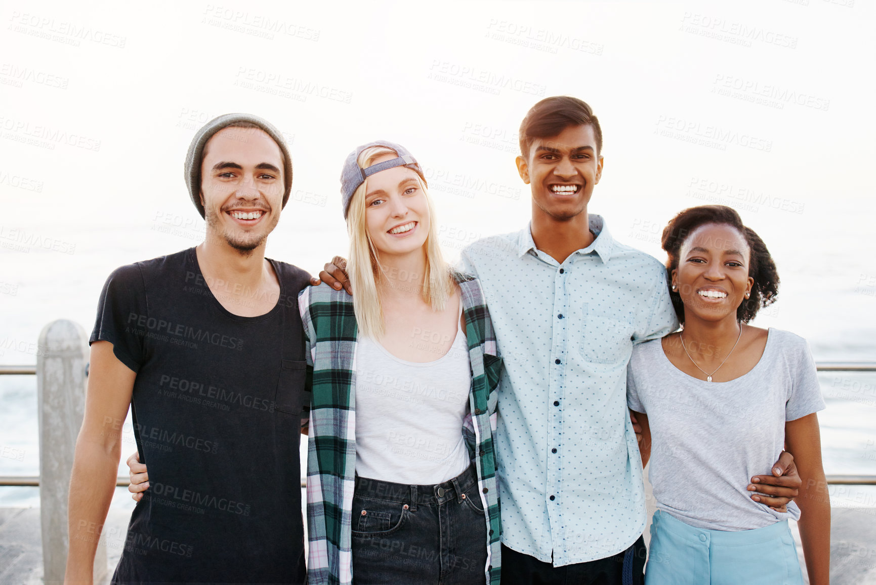 Buy stock photo Friends, group and portrait on beach with hug for travel, bonding and happy outdoor on promenade. Diversity, gen z people and embrace by ocean for holiday, boardwalk and summer adventure in nature