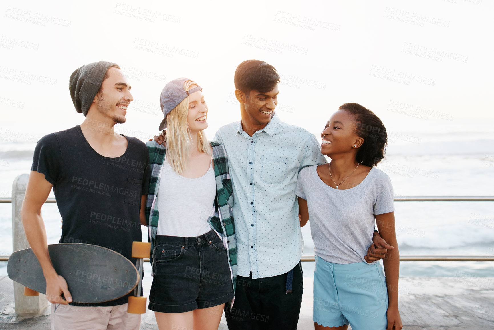 Buy stock photo Group, friends and happy for hug on promenade by ocean for diversity, bonding or care on holiday. Men, women or gen z people with smile, embrace and outdoor on boardwalk for youth culture on vacation