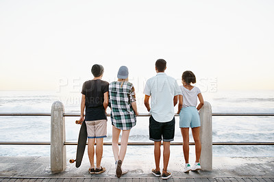 Buy stock photo Sunrise, fashion and back of friends by ocean for holiday, summer vacation and weekend outdoors. Diversity, promenade and men and women by seaside for travel, adventure and relax together for bonding