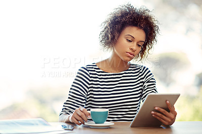 Buy stock photo Shot of a young woman drinking tea while working at home with a digital tablet