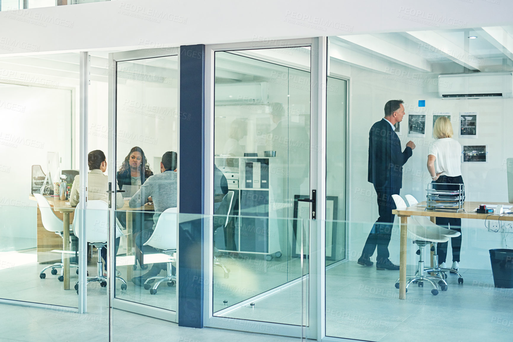 Buy stock photo Shot of corporate colleagues working together in their office