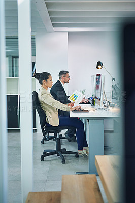 Buy stock photo Shot of corporate colleagues working together in their office