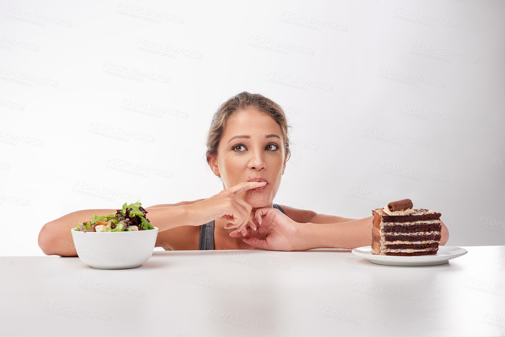 Buy stock photo Studio shot of an attractive young woman being tempted by something sweet