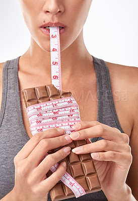 Buy stock photo Studio shot of an attractive young woman being tempted by something sweet