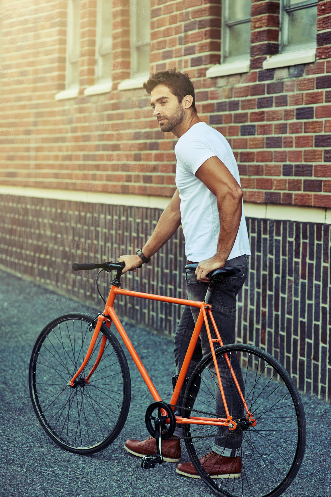 Buy stock photo Walking, bicycle and man by brick wall in city for sightseeing on vacation, holiday or adventure. Outdoor, travel and male person with bike for carbon footprint in town on weekend trip in Netherlands