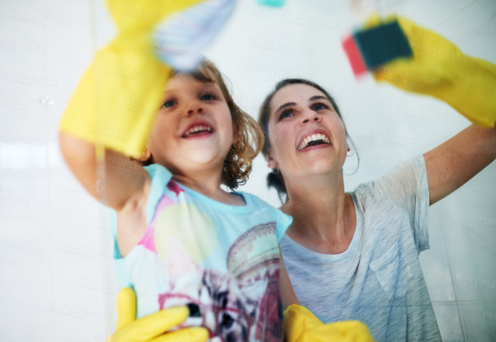 Buy stock photo Shot of a mother and daughter doing chores together at home