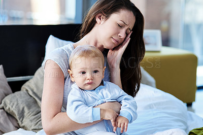 Buy stock photo Tired, sick and a mother with a child and headache from parenting stress, burnout and sad. Fatigue, mental health and a mom with postpartum depression, anxiety or pain with a newborn at home