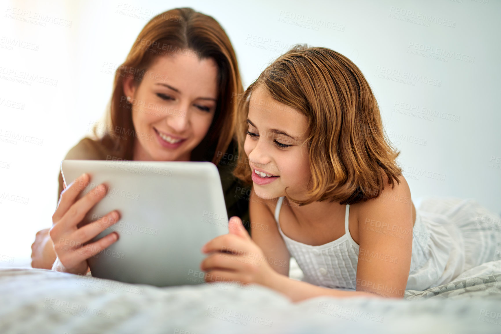 Buy stock photo Smile, mother and child on tablet in bed at home together for game, relax and family streaming movie. Happy girl, mom and technology in bedroom for learning, education or reading ebook on app online