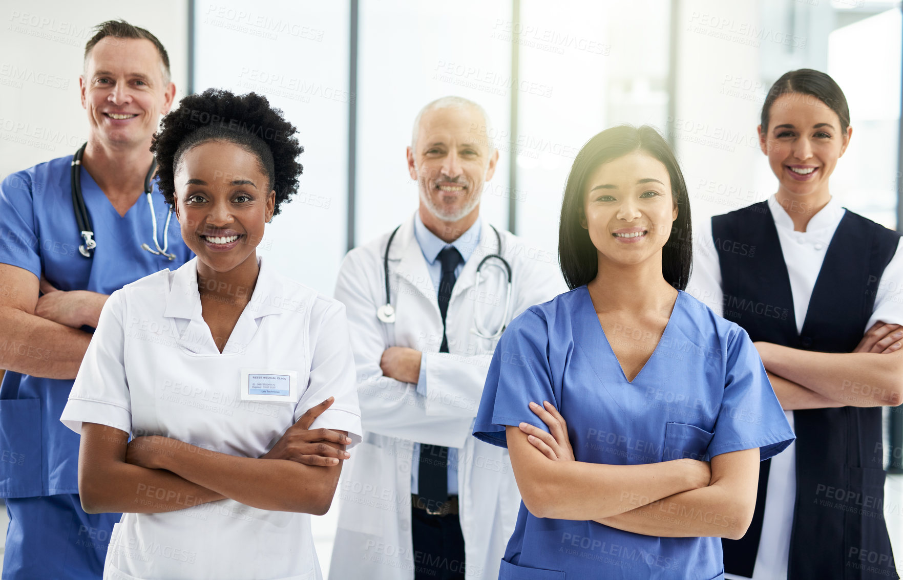 Buy stock photo Confidence, crossed arms and portrait of team of doctors standing in the hallway with collaboration. Happy, diversity and group of healthcare workers in the corridor of a medical clinic or hospital.