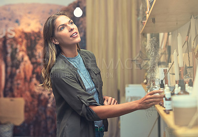 Buy stock photo Shot of a young woman looking at products in a store