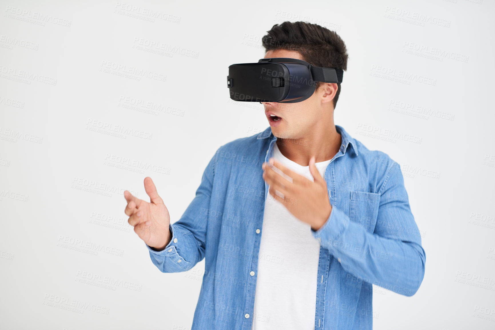 Buy stock photo Studio shot of a young man looking amazed while wearing a VR headset against a white background